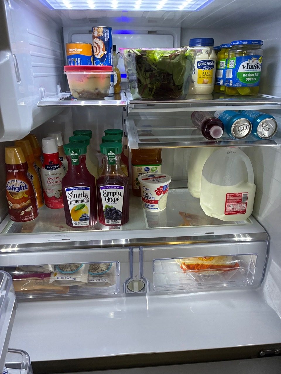 Full, cluttered refrigerator before a Spotless clean