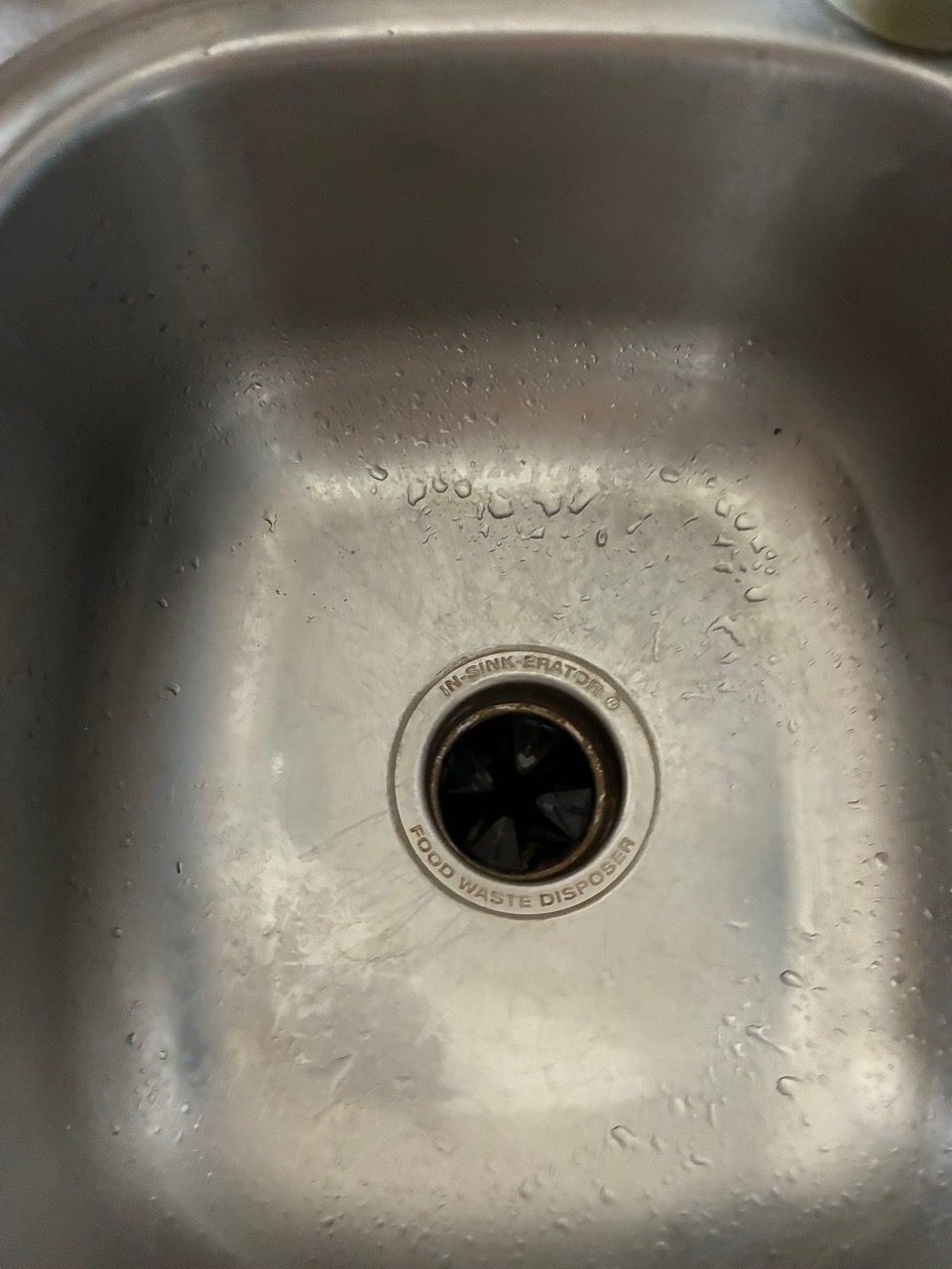 The same stainless kitchen sink scrubbed and polished after a move-out clean