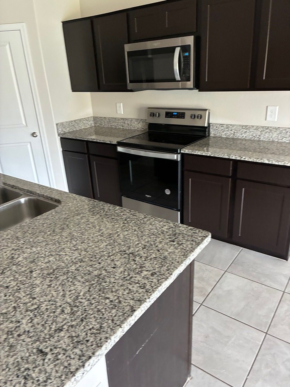 Clean kitchen island with polished granite counters after a residential cleaning