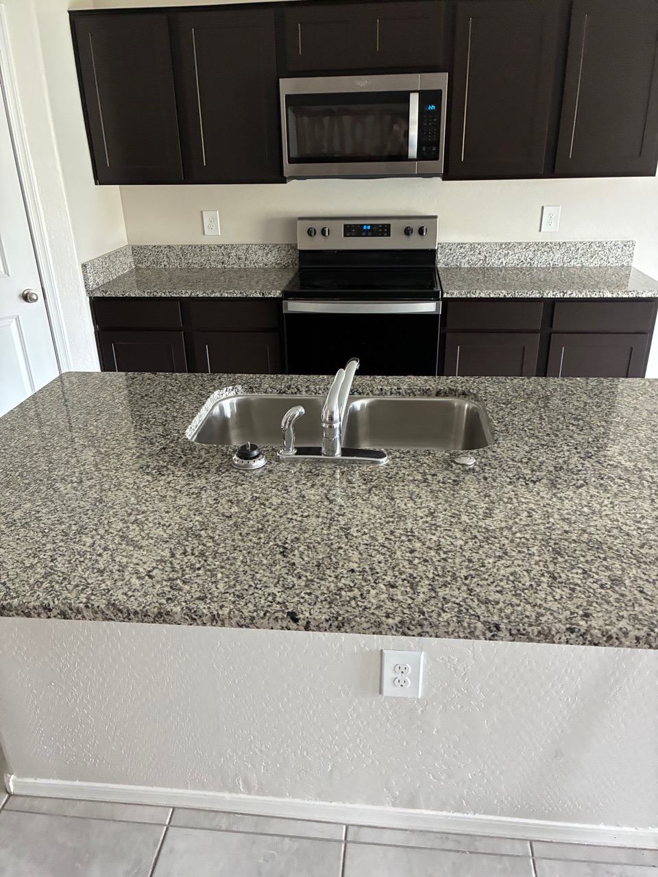 Clean kitchen with stainless range and dark cabinets after a residential clean