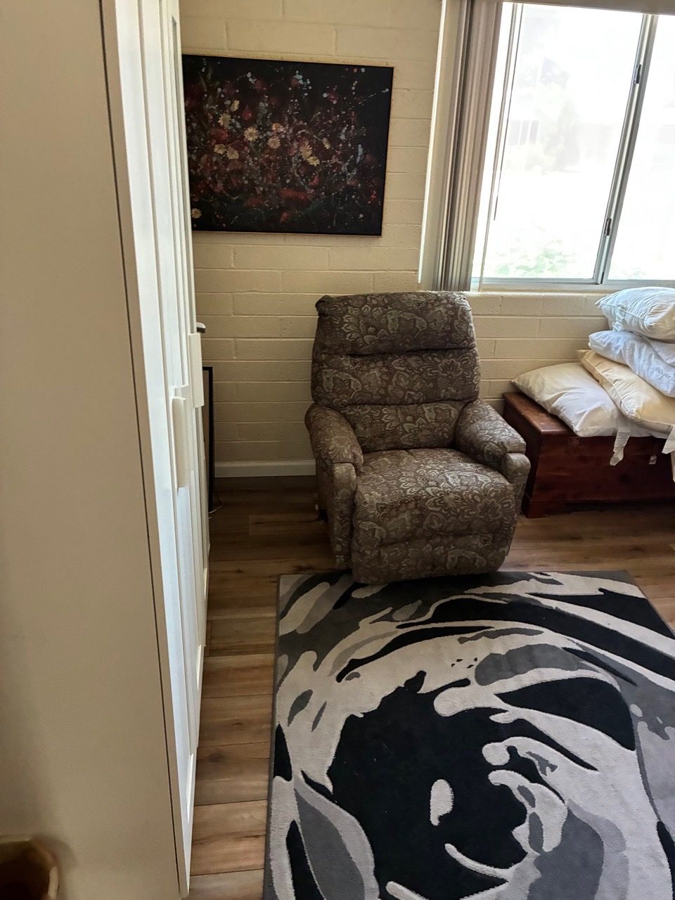 Tidy living area with clean recliner and polished hardwood floor
