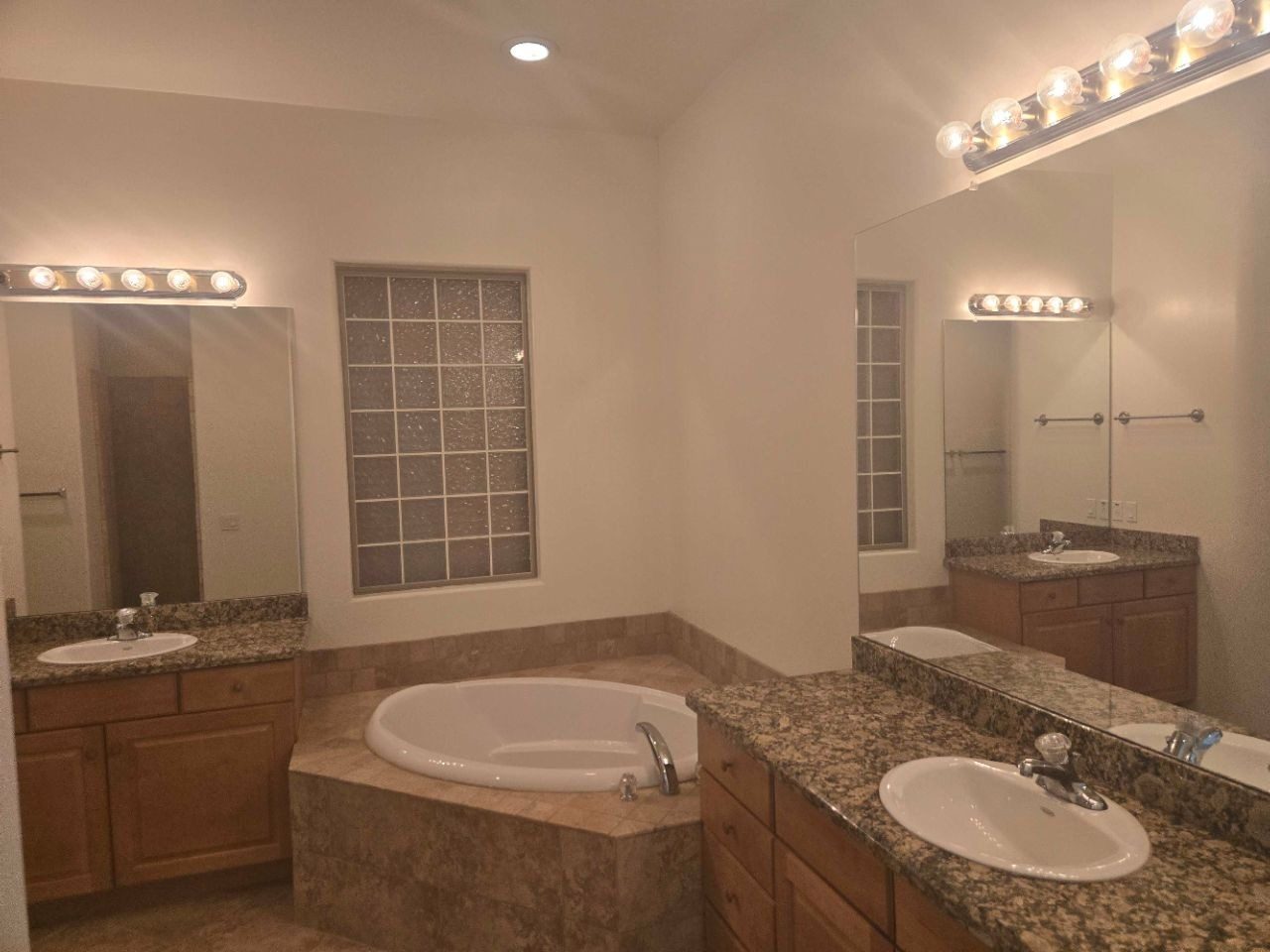 Spacious master bathroom with double vanity and garden tub after a deep clean